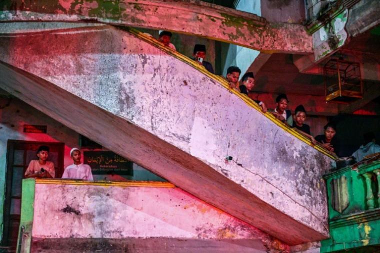 Des étudiants observent les recherches des secours pour trouver des survivants à l'école islamique effondrée de Sidoarjo, en Indonésie, le 29 septembre 2025 ( AFP / Juni KRISWANTO )