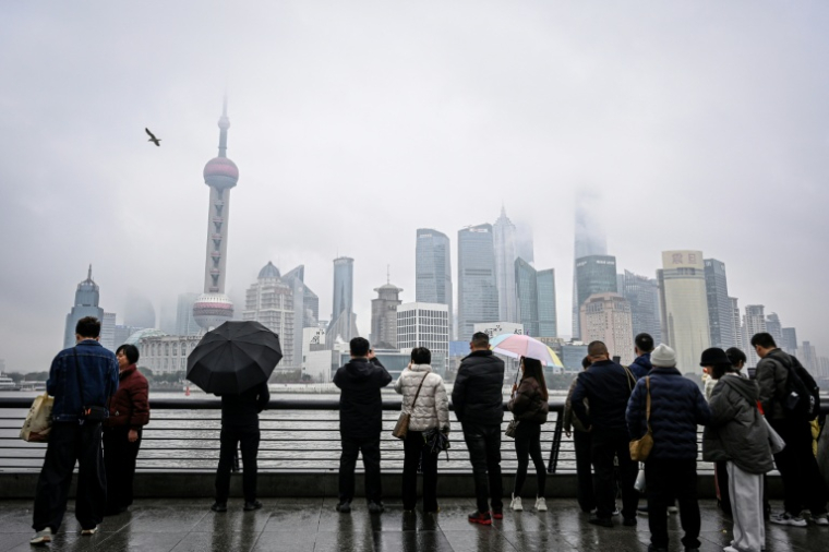 Des personnes se promènent sur le Bund, le long du fleuve Huangpu à Shanghai, le 5 mars 2026 ( AFP / Jade GAO )