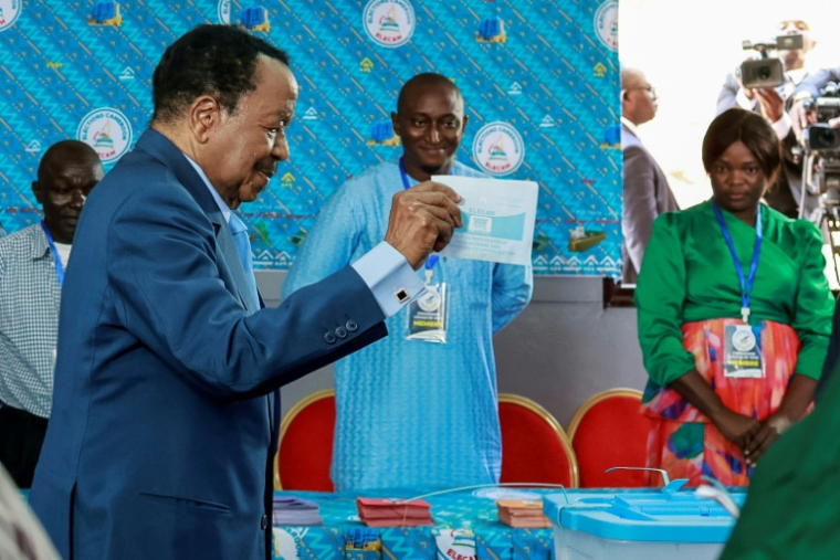 Paul Biya, 92 ans, glisse son bulletin dans l'urne à Yaoundé le 12 octobre 2025 ( AFP / Daniel BELOUMOU OLOMO )