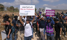 Des militants israéliens et des bénévoles solidaires rassemblés devant une maison palestinienne assiégée par des colons israéliens dans le village de Qusra, au sud de Naplouse, en Cisjordanie occupée, le 14 août 2026 ( AFP / JAAFAR ASHTIYEH )