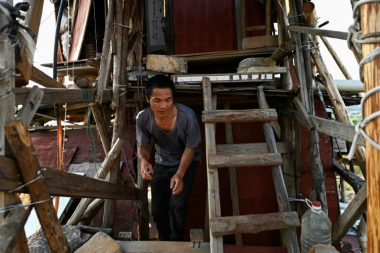 Chen Tianming dans sa "maison clou" à Xingyi, dans la province du Guizhou, le 20 mai 2025 au sud-ouest de la Chine ( AFP / Pedro PARDO )