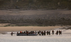 Un groupe de migrants débarque d'un canot pneumatique sur la plage de Le Portel, dans le nord de la France