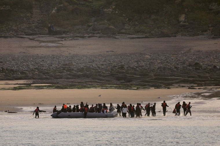Un groupe de migrants débarque d'un canot pneumatique sur la plage de Le Portel, dans le nord de la France