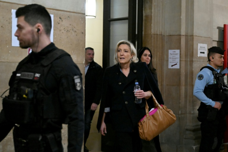 Marine Le Pen (c), présidente du groupe parlementaire du Rassemblement National (RN), accompagnée de Catherine Griset (d), eurodéputée du RN, arrive au tribunal de Paris, le 20 janvier 2026, pour l'audience en appel des assistants parlementaires du Rassemblement National (RN) soupçonnés de détournement de fonds publics européens ( AFP / Bertrand GUAY )
