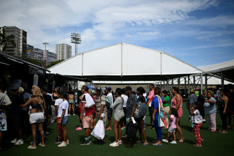 Des habitants déplacés à la suite des deux séismes du 24 juin au Venezuela font la queue pour un repas dans un camp installé dans un complexe sportif de l’État de La Guaira, le 30 juin 2026 ( AFP / Federico PARRA )