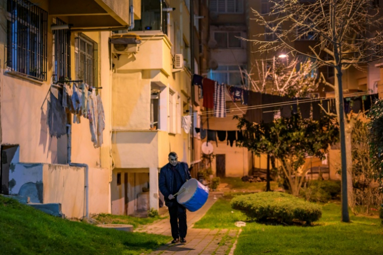 Un joueur de davul, tambour à deux faces, sonne l'heure du dernier repas avant d'entamer le jeûne du ramadan à l'aube, le 24 février 2026 à Istanbul ( AFP / Yasin AKGUL )