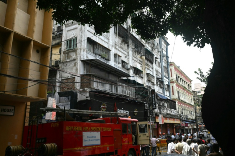 Des pompiers sur les lieux d'un incendie dans un hôtel à Calcutta, le 19 août 2026 en Inde ( AFP / Dibyangshu SARKAR )