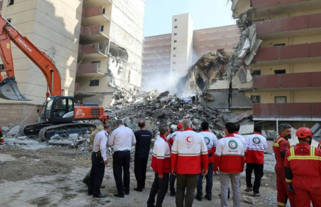 Photo diffusée par le Croissant-Rouge iranien le 14 juin 2025 montrant des bénévoles rassemblés devant un bâtiment détruit lors d'une frappe israélienne à Téhéran ( Iranian Red Crescent / - )