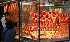 Des passants devant la vitrine d'une boutique d'or, à Hong Kong, le 26 janvier 2026 ( AFP / Peter PARKS )