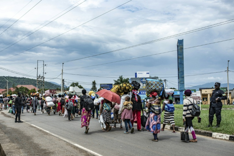 Des réfugiés fuyant d'intenses bombardements dans la région de Kamanyola, dans l'est de la République démocratique du Congo, sont encadrés par les forces de sécurité à Bugarama, au Rwanda voisin, le 5 décembre 2025 ( AFP / - )