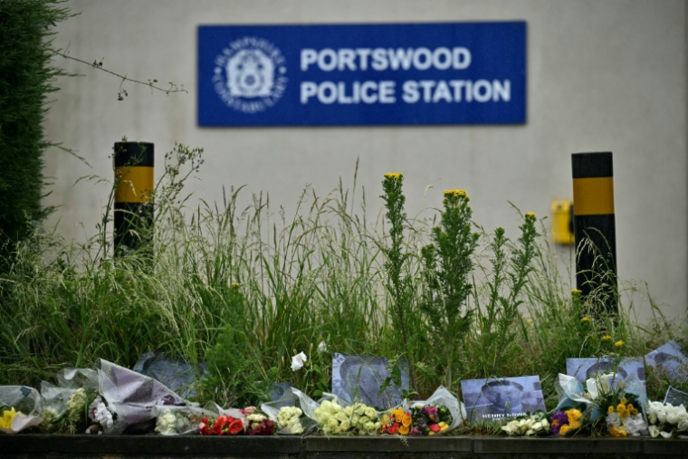 Des portraits de l'étudiant Henry Nowak et des fleurs déposés devant le commissariat de police de Portswood, à Southampton, dans le sud de l'Angleterre, le 3 juin 2026 ( AFP / Ben STANSALL )