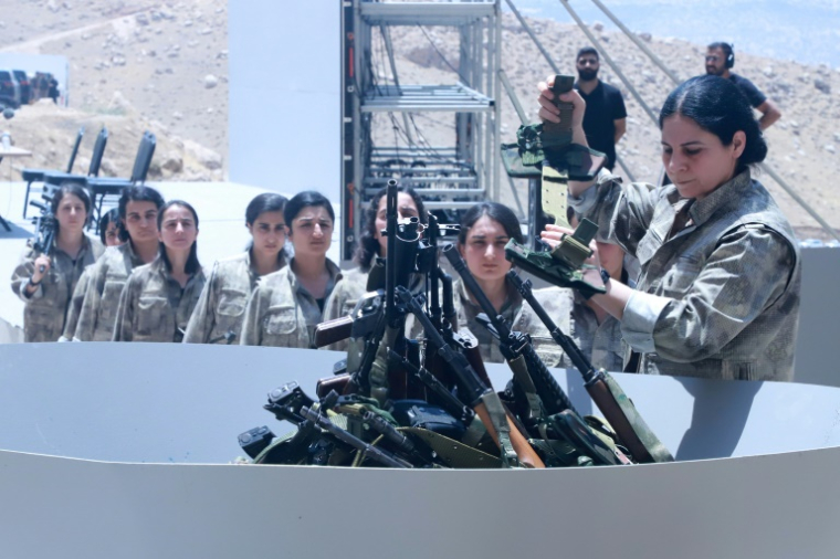 Des combattants du Parti des Travailleurs du Kurdistan (PKK) déposent leurs armes dans une grande vasque lors d’une cérémonie à Souleimaniyeh, dans la région autonome du Kurdistan irakien, le 11 juillet 2025 ( AFP / Shwan MOHAMMED )