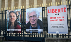 Les portraits de Cécile Kohler et de Jacques Paris, emprisonnés en Iran, accrochés aux grilles de l'Assemblée nationale à Paris, le 25 mars 2025 ( AFP / Bertrand GUAY )