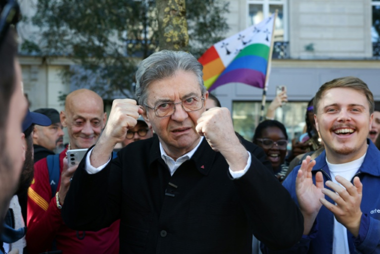 Jean-Luc Mélenchon (au centre), candidat du parti de gauche La France Insoumise (LFI) à la présidentielle de 2027, pose les poings levés aux côtés du député LFI Louis Boyard (droite), à Paris, le 3 octobre 2026 ( AFP / Kenzo TRIBOUILLARD )