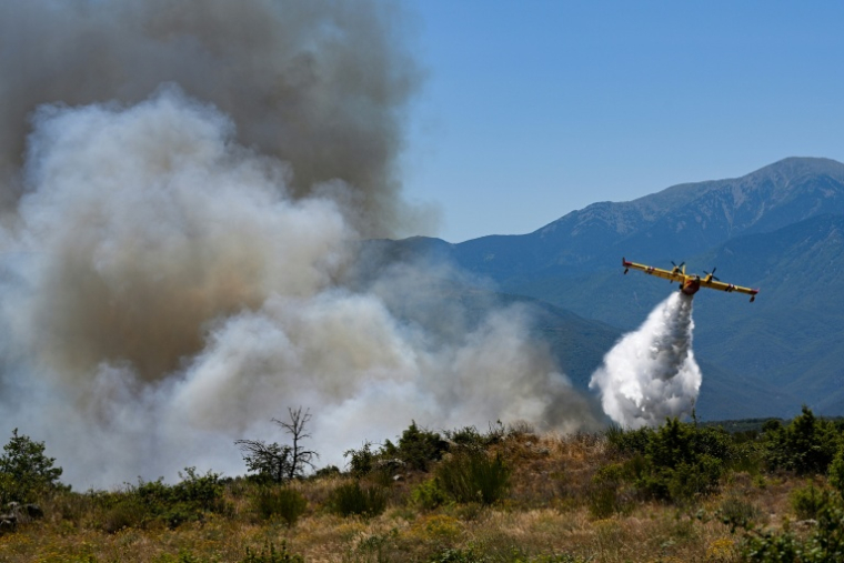 Un avion Canadair CL-415 de la Sécurité civile française largue de l’eau sur un incendie de forêt au col des Auzines, près de Trévillach, dans le sud de la France, le 5 juillet 2026 ( AFP / Matthieu RONDEL )