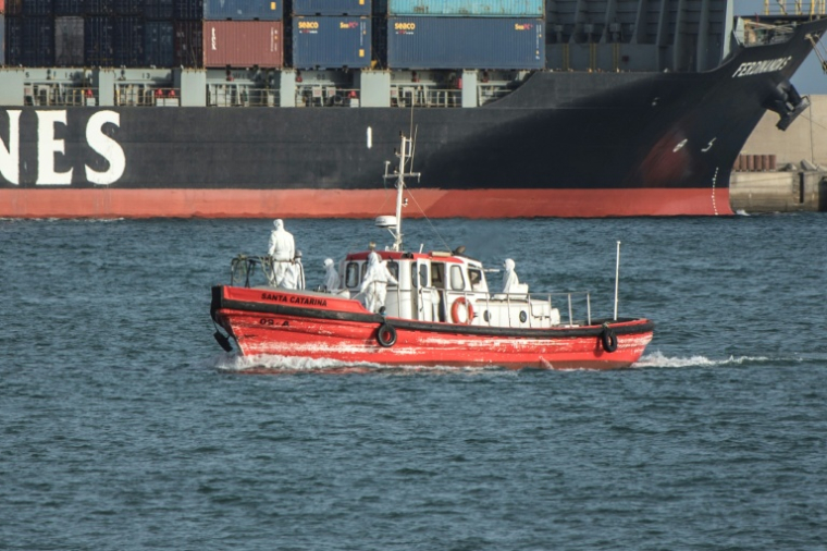 Un bateau-ambulance, transportant des membres d'équipage en combinaisons de protection, retourne au port de Praia, après une visite au paquebot MV Hondius, stationné au large, le 5 mai 2026 au Cap-Vert ( AFP / - )