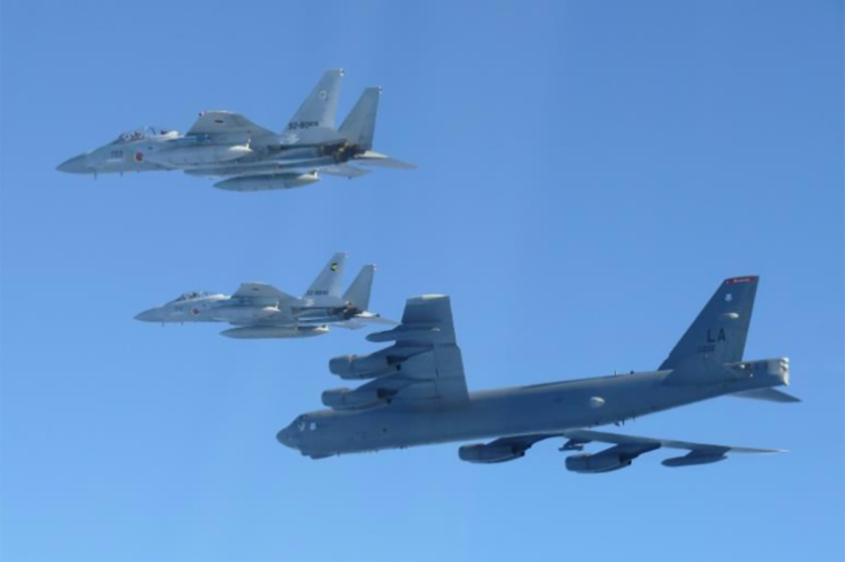Photo prise le 10 décembre 2025 et diffusée le 11 décembre 2025 par le ministère japonais de la Défense montrant un bombardier stratégique B-52 de l'US Air Force (en bas) et deux chasseurs F-15 des Forces d'autodéfense aériennes japonaises effectuant un exercice conjoint au-dessus de la mer du Japon ( Japan's Ministry of Defense / Handout )