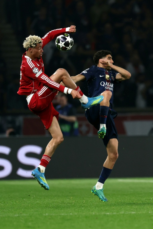 Le défenseur du Paris SG Achraf Hakimi (D) et l'attaquant français de Liverpool Hugo Ekitike lors de la victoire parisienne 2 à 0 en quart de finale aller de Ligue des champions, le 8 avril 2026 au Parc des Princes ( AFP / Anne-Christine POUJOULAT )