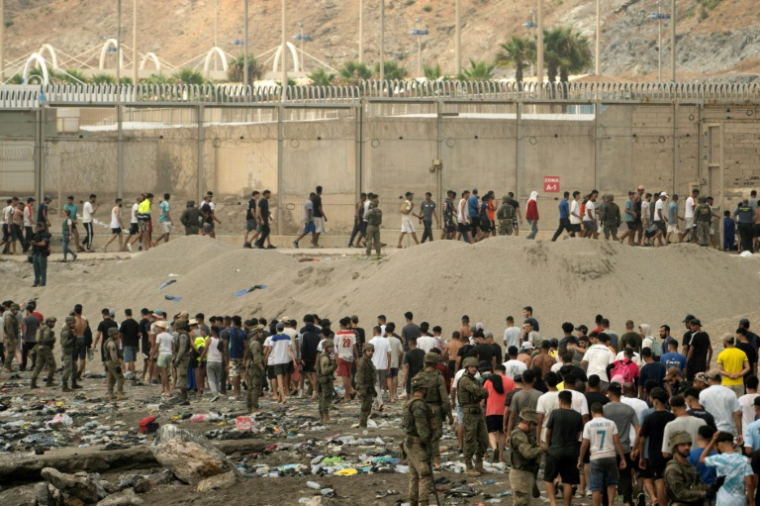 Des soldats espagnols contrôlent des migrants qui retournent au Maroc après avoir franchi la frontière pour entrer dans l’enclave espagnole de Ceuta, en Afrique du Nord, le 31 juillet 2026 ( AFP / JORGE GUERRERO )