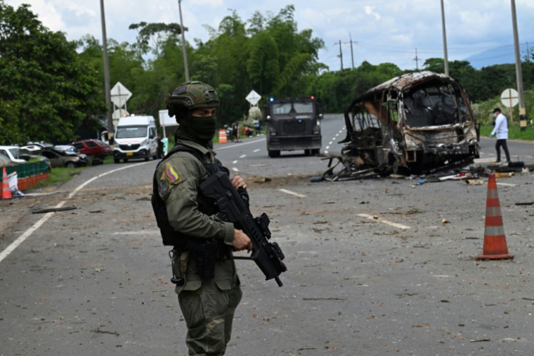 Un militaire devant les restes d'un bus piégé qui a explosé devant le poste de police de Villa Rica, dans le département de Cauca, en Colombie, le 10 juin 2025 ( AFP / Joaquin Sarmiento )