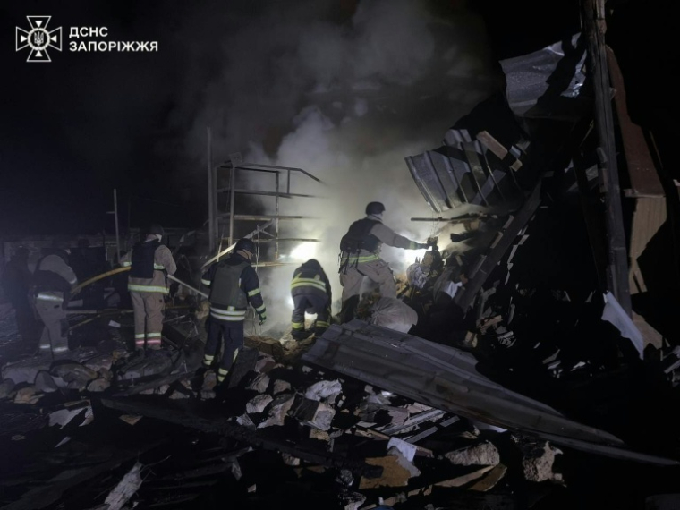 Photo diffusée par les services d'urgence ukrainiens ,le 24 décembre 2025, montrant des secouristes ukrainiens sur le site d'une frappe aérienne à Zaporijjia ( Services d'urgence ukrainiens / Handout )