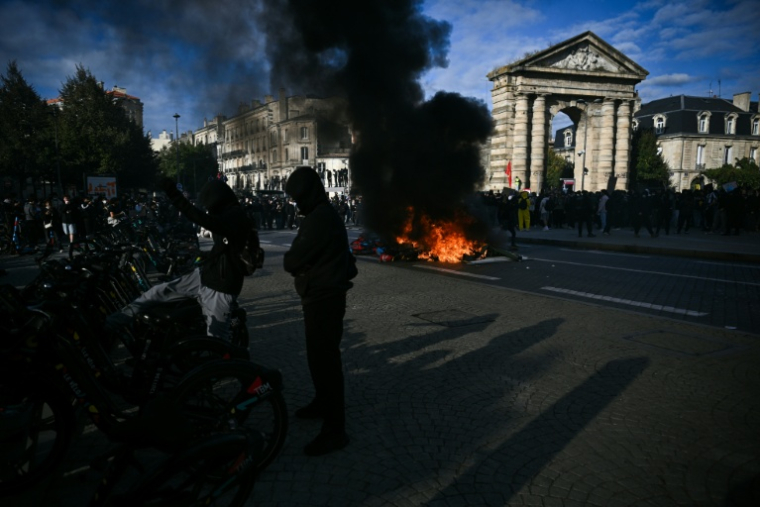 Un protestataire donne un coup de pied dans un vélo près d’un feu, lors d’une manifestation contre la vie chère à Bordeaux, le 17 octobre 2026 ( AFP / Christophe ARCHAMBAULT )