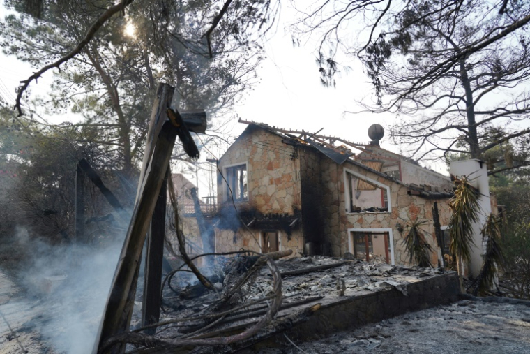 De la fumée s'élève des braises d'une maison détruite par le feu dans le village chypriote de Souni, dans la province de Limassol, le 24 juillet 2025 ( AFP / Etienne TORBEY )
