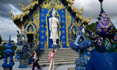 Des touristes visitent le temple bouddhiste Wat Rong Suea Ten, dit "Temple Bleu", dans la province de Chiang Rai, au nord de la Thaïlande, le 26 mai 2025 ( AFP / MANAN VATSYAYANA )