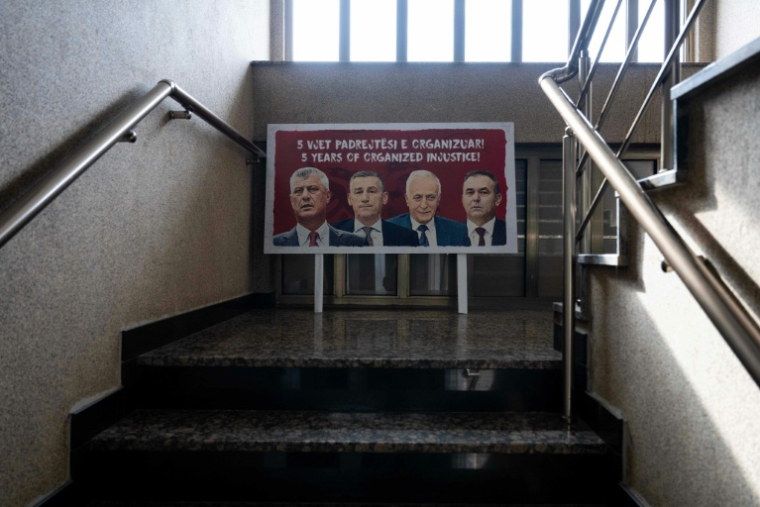 Une affiche dans les locaux de l'Organisation des anciens combattants de l'Armée de libération du Kosovo montrant l'ancien président Hashim Thaci (g), les anciens présidents du Parlement Kadri Veseli et Jakup Krasniqi, et l'ancien député Rexhep Selimi, à Pristina, le 9 février 2026 ( AFP / Armend NIMANI )