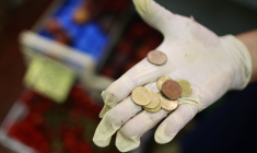 Un vendeur tient des pièces d'euros sur un marché du centre de Rome