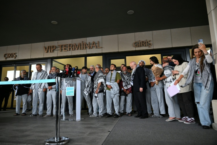 Des militants de la "flottille pour Gaza", arrêtés et expulsés par Israël, devant un terminal après leur arrivée à l'aéroport d'Istanbul, le 21 mai 2026 en Turquie ( AFP / Ozan KOSE )