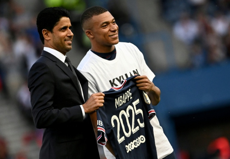 Kylian Mbappé (à droite) avec le président du Paris SG Nasser Al-Khelaifi le 21 mai 2022 au Parc des Princes après l'annonce de sa prolongation de contrat jusqu'à l'été 2024 ( AFP / Anne-Christine POUJOULAT )