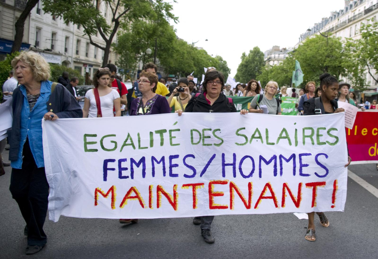 Une femme brandit une banderole où l'on peut lire "Égalité salariale femmes/hommes maintenant" lors d'une manifestation à Paris le 1er mai 2011. ( AFP / MIGUEL MEDINA )