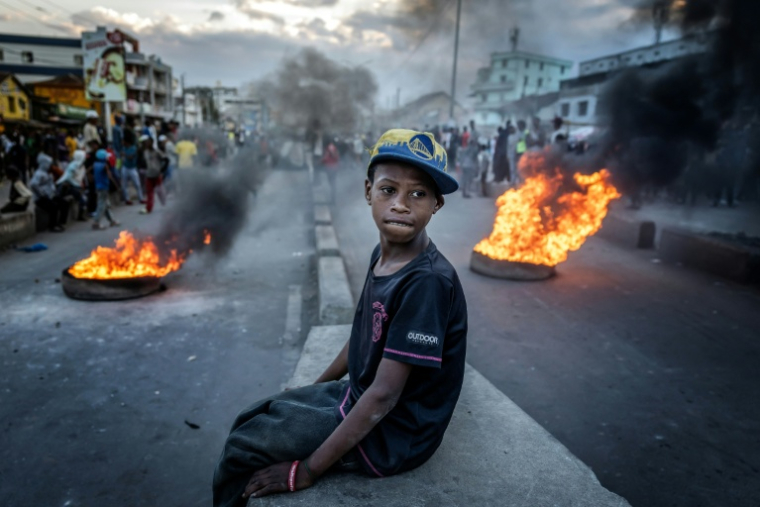 Image du photographe Luis Tato montrant un enfant assistant à des affrontements entre manifestants et forces de l'ordre lors du mouvement de la Gen Z malgache, à Antananarivo le 9 octobre 2025 ( AFP / Luis TATO )
