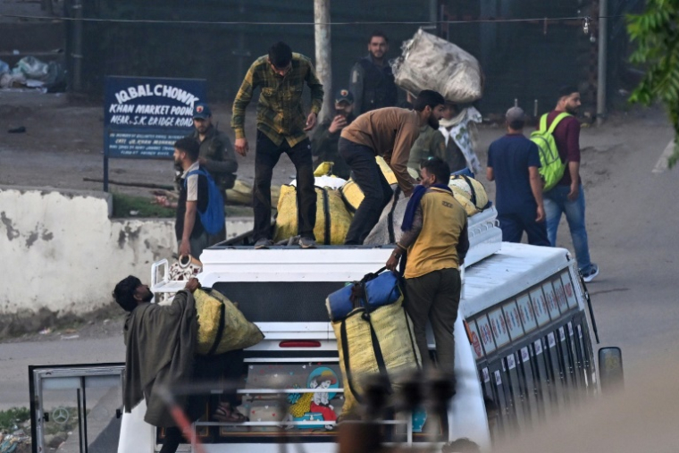 Des habitants chargent leurs affaires sur le toit d'un bus pour fuir le village de Poonch après un bombardement d'artillerie, dans la région de Jammu, en Inde, le 7 mai 2025 ( AFP / Punit PARANJPE )