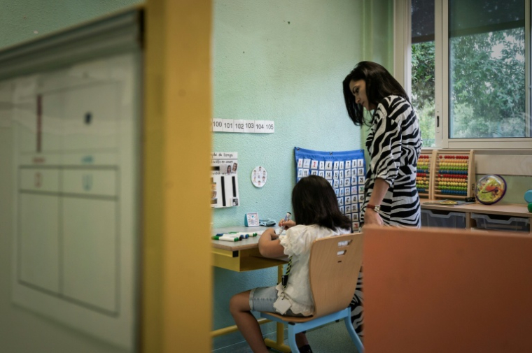 Un enfant autiste suit un cours dispensé par un accompagnateur scolaire pour élèves handicapés (AESH), à Cenon (Gironde), le 2 septembre 2022 ( AFP / Philippe LOPEZ )