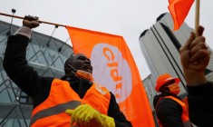 Des travailleurs tiennent des drapeaux du syndicat CFDT lors d'une manifestation à Paris