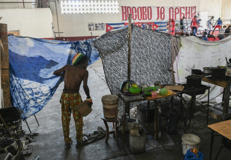 Un homme regarde dehors depuis l'entrée de son abri de fortune, dans une salle de boxe où des familles sans domicile se sont installées, dans la Vieille Havane, le 9 juin 2026, à Cuba ( AFP / YAMIL LAGE )