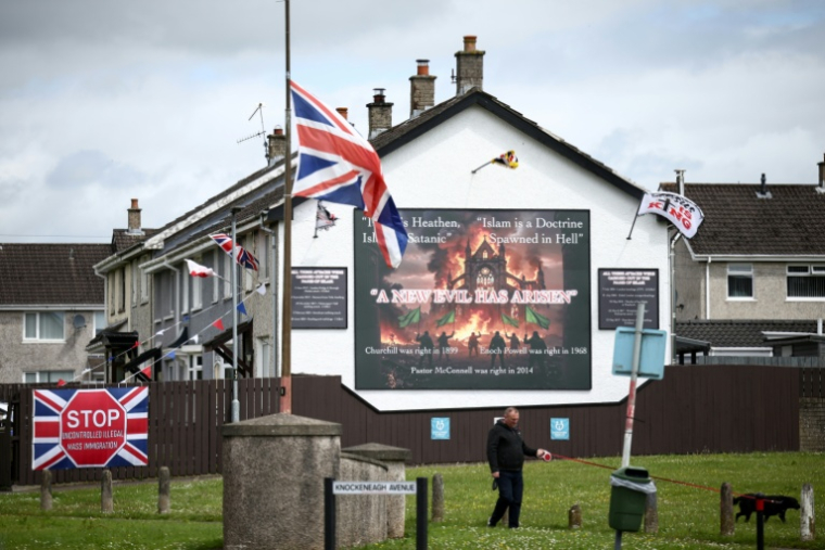 Une fresque murale anti-islam et une banderole anti-immigration à Whiteabbey, dans le nord de Belfast, en Irlande du Nord, le 12 juin 2026 ( AFP / Henry NICHOLLS )