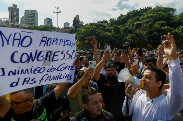 Des livreurs à vélo et des travailleurs sur application manifestent contre les réglementations gouvernementales à São Paulo, au Brésil, le 14 avril 2026.  ( AFP / Miguel SCHINCARIOL )