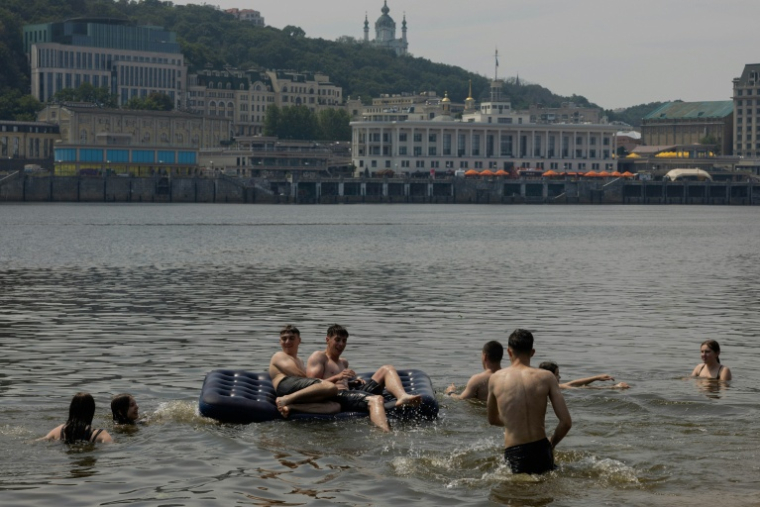 Des adolescents jouent sur un matelas gonflable dans les eaux du Dniepr, à Kiev, en Ukraine, le 29 juin 2026. ( AFP / Tetiana DZHAFAROVA )