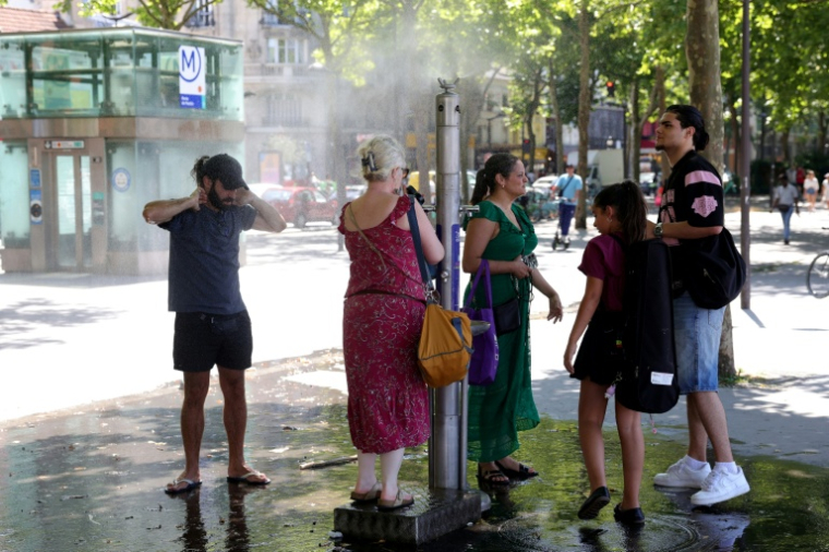 Des personnes se rafraîchissent lors d'une vague de chaleur, le 21 juin 2025 à Paris ( AFP / ROMAIN PERROCHEAU )
