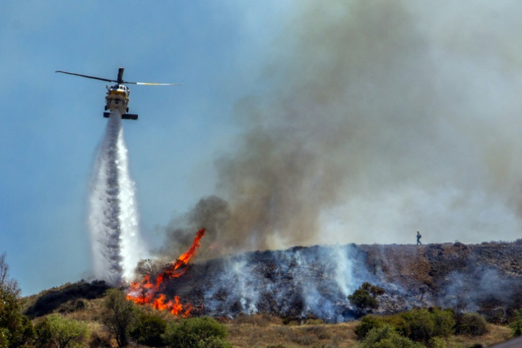 Un hélicoptère largue de l'eau sur les flammes du "Sandy Fire", dans les collines de Simi Valley, près de Los Angeles, le 18 mai 2026 ( AFP / Apu GOMES )