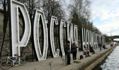 Des pêcheurs devant des lettres géantes "La Russie commence ici" sur la rivière Velikaïa à Pskov, le 17 avril 2026 en Russie (  / Olga MALTSEVA )