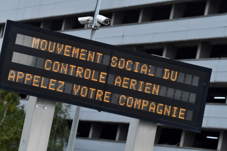 Un panneau d'information sur lequel on peut lire "mouvement social du contrôle aérien appelez votre compagnie" à l'aéroport Paris-Charles-de-Gaulle, dans la banlieue nord-est de Paris, le 16 septembre 2022 ( AFP / JULIEN DE ROSA )