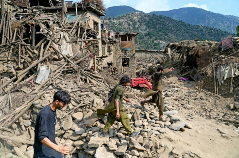 Des Afghans passent devant des maisons endommagées à la suite de séismes dans le village de Mazar Dara, situé dans le district de Nurgal (province de Kounar), dans l'est de l'Afghanistan, le 1er septembre 2025 ( AFP / Wakil Kohsar )