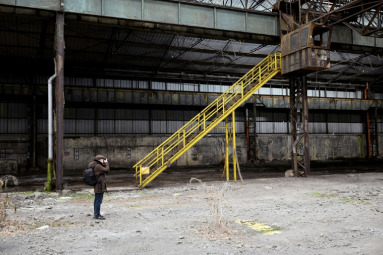 Un explorateur urbain (urbex) prend des photos dans une aciérie à l'abanon à Charleroi, dans le sud de la Belgique, le 9 février 2026 ( AFP / Nicolas TUCAT )
