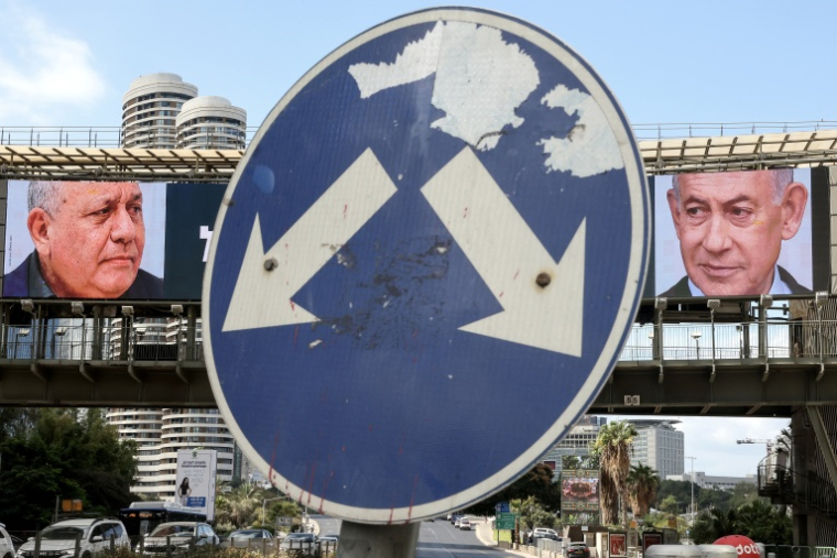 Le candidat centriste au poste de Premier ministre Gadi Eisenkot (g) et l'actuel Premier ministre Benjamin Netanyahu apparaissent sur des écrans installés sur un pont enjambant une rue de Ramat Gan, en Israël, le 20 octobre 2026 ( AFP / Jack GUEZ )
