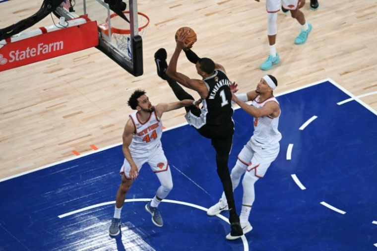 Le basketteur français des San Antonio Spurs Victor Wembanyama tire au panier sous la défense de Landry Shamet et de Josh Hart des New York Knicks, lors du troisième match de la finale de la NBA au Madison Square Garden de New York, le 8 juin 2026 ( AFP / SAUL LOEB )