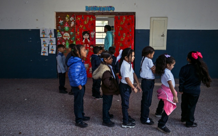 Des élèves font la queue pour entrer dans leur salle de classe à Caracas, le 12 janvier 2026 ( AFP / Juan BARRETO )